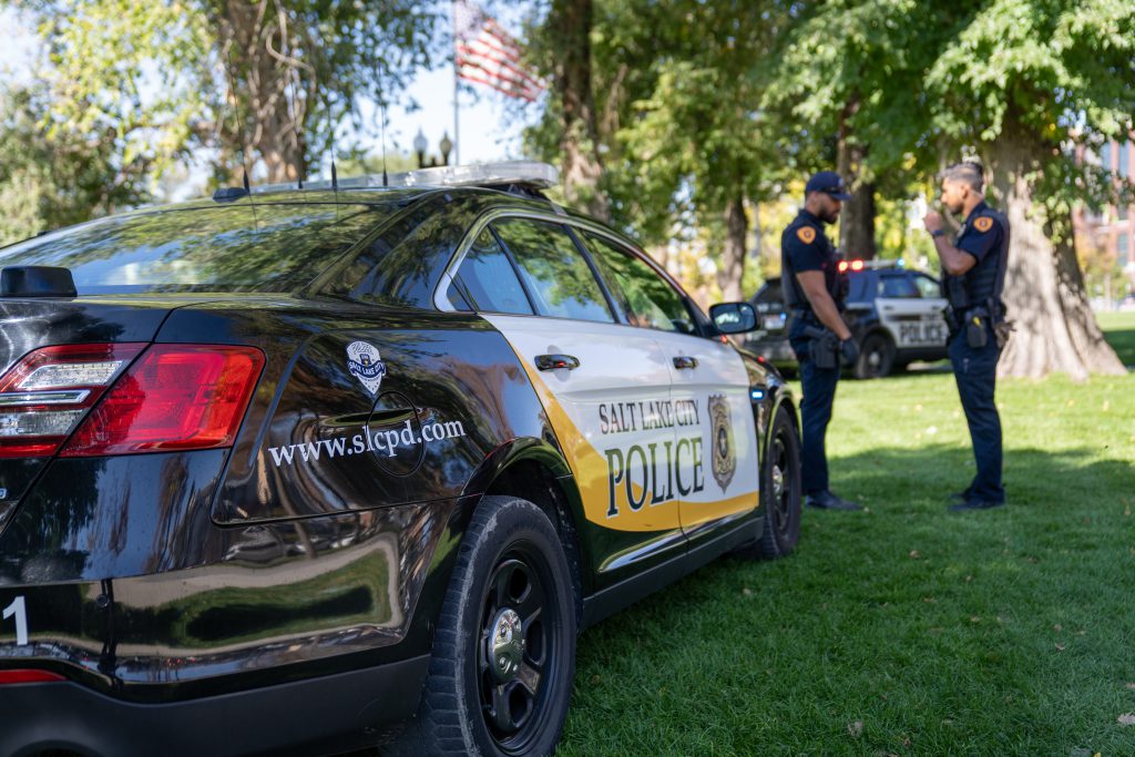 a police car in a park with officers nearby
