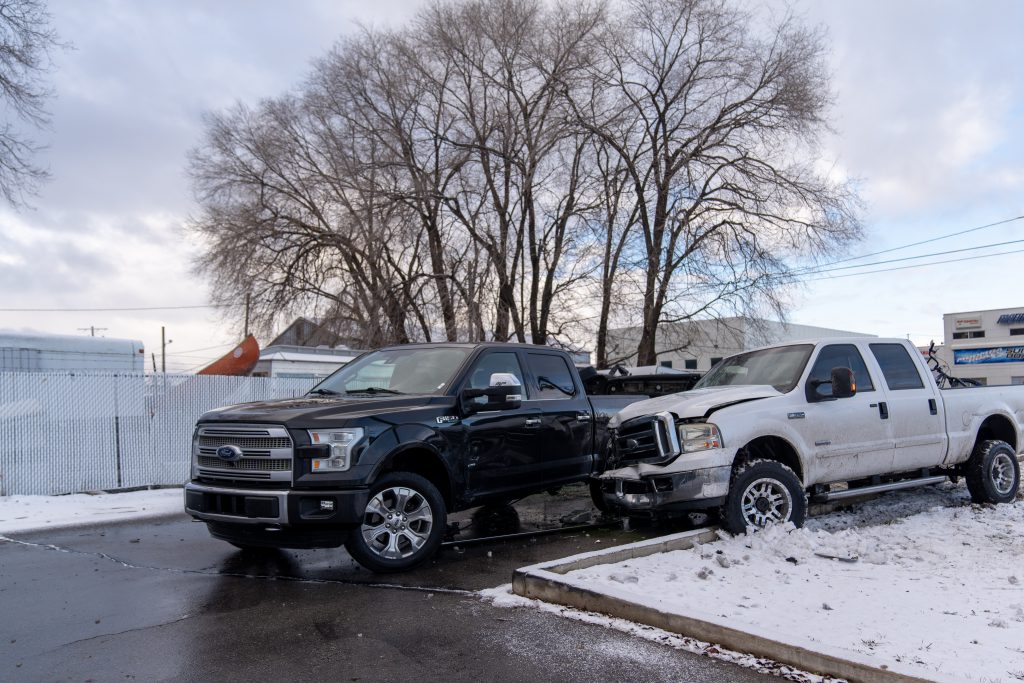 A photo of a dark-colored truck and white truck involved in a crash.