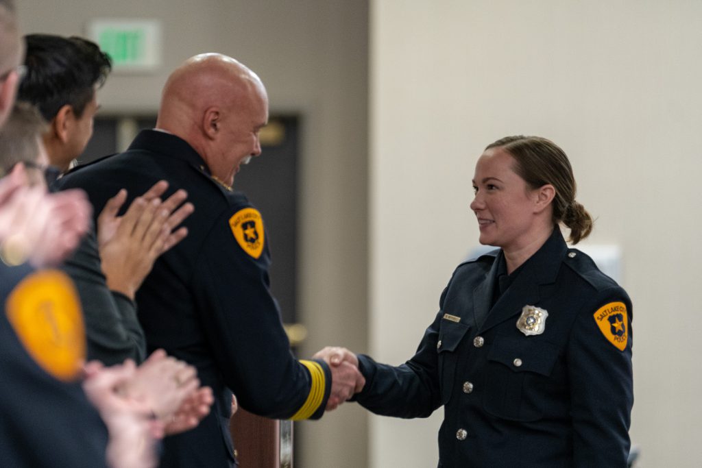 One of the newest Salt Lake City police officers being congratulated by SLCPD Command Staff members.