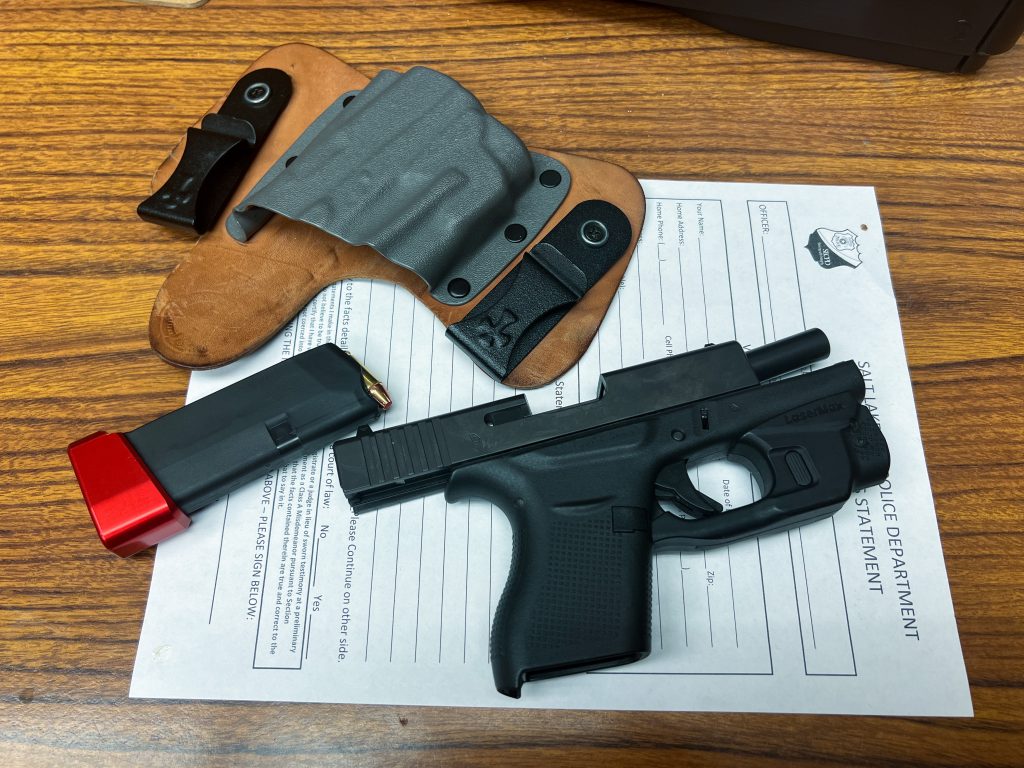 A hand gun, magazine, and holster laying on a paper
