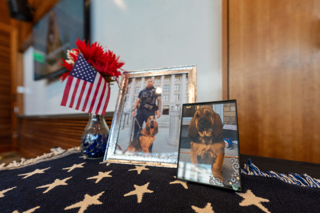 A photo of memorial decorations including a picture of K9 Bruce and his handler and K9 Bruce as a puppy (SLCPD photo - April 17, 2024).