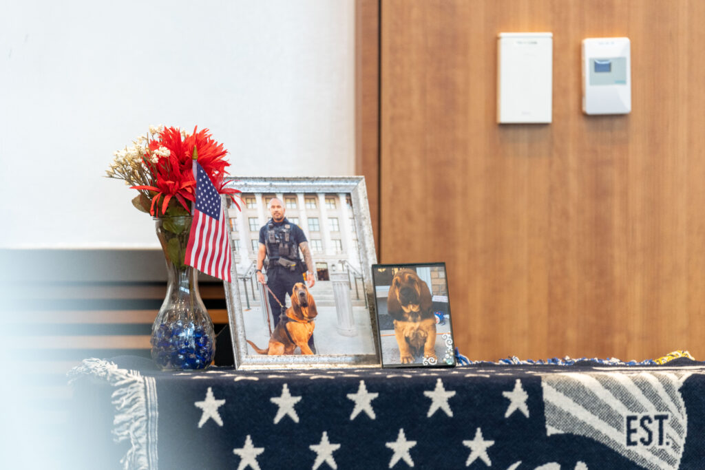 A photo of memorial decoration including a picture of K9 Bruce and his handler and K9 Bruce as a puppy (SLCPD photo - April 17, 2024).